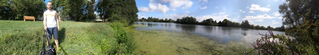 Lago tranquilo com vegetação ao redor.