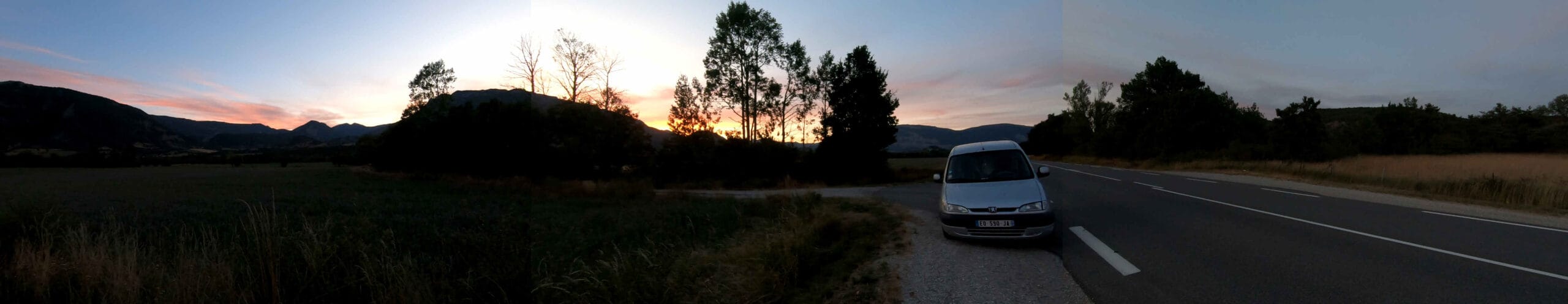 Pôr do sol com carro na estrada